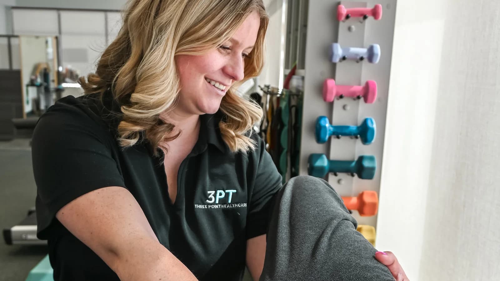 A 3PT Bourbonnais physical therapist performing hands-on knee examination on a patient at the clinic.