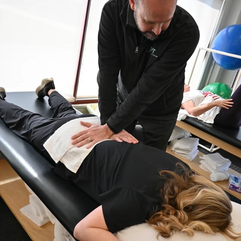 A 3PT Bourbonnais physical therapist performing hands-on manual therapy on a patient's lower back at the clinic.