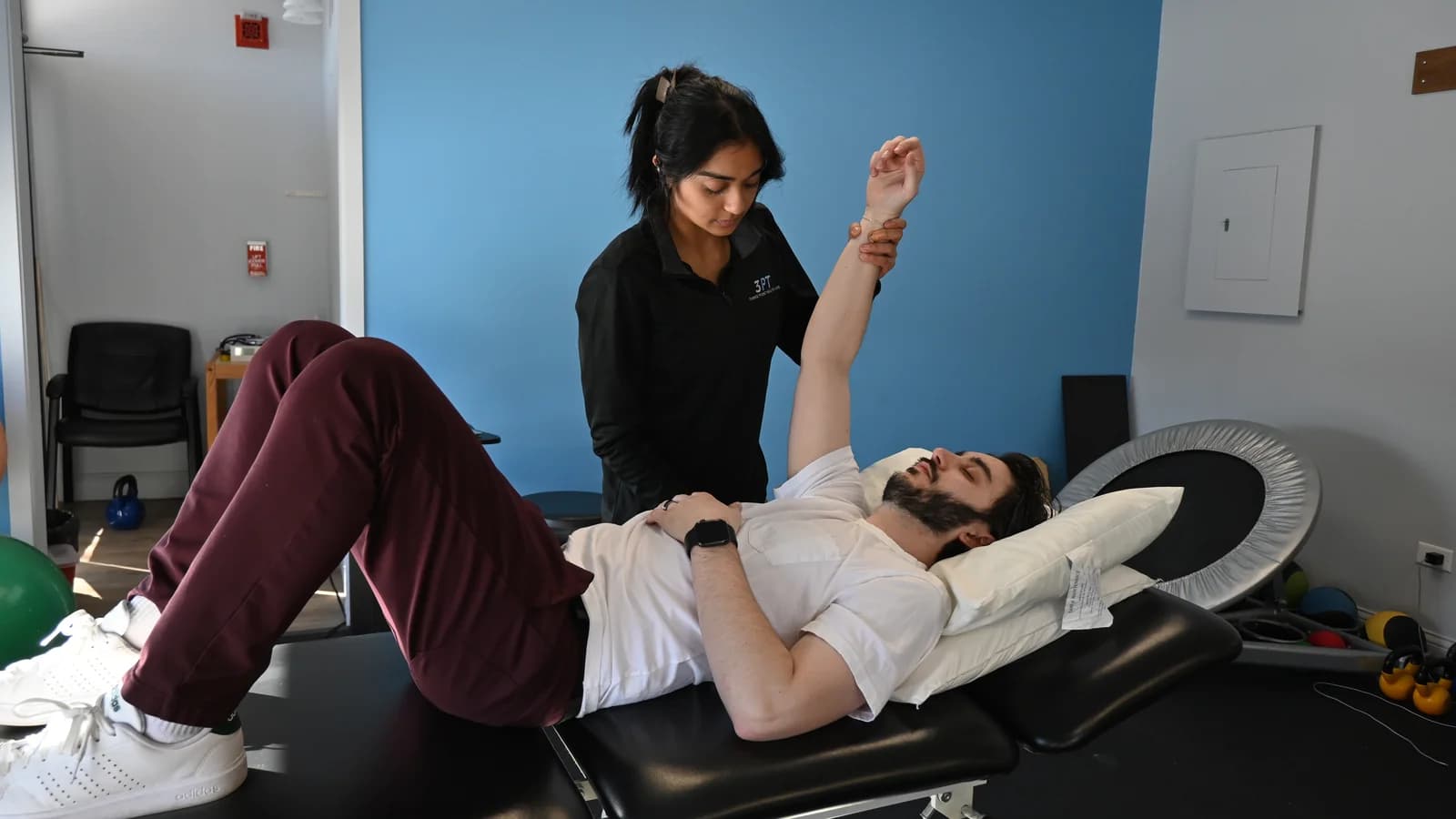 A 3PT La Grange physical therapist performing hands-on shoulder range of motion on a patient at the clinic.