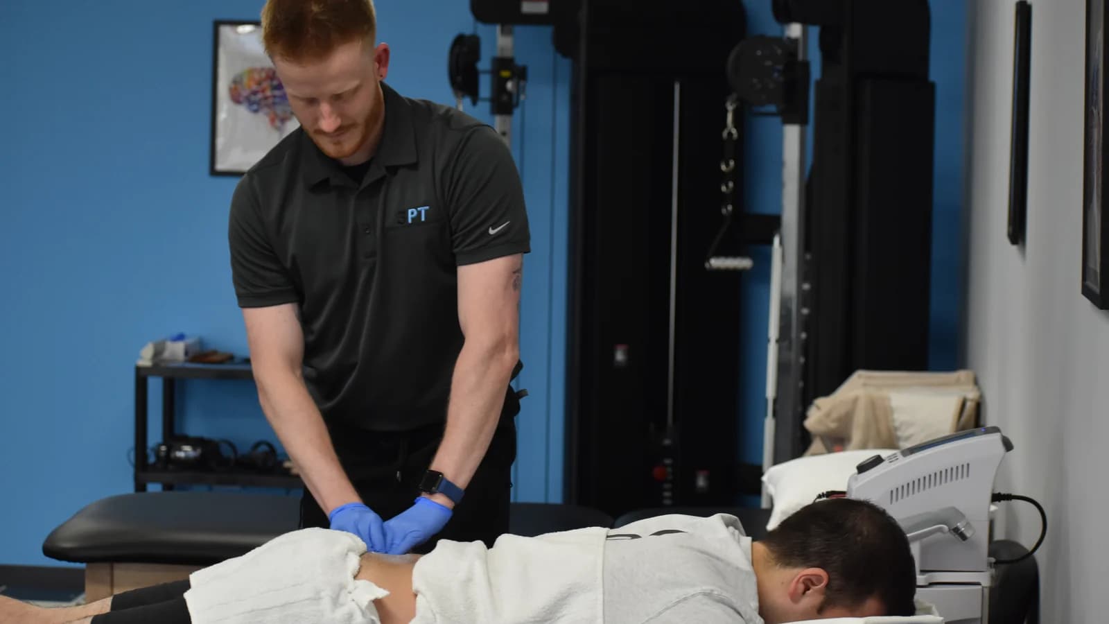 A 3PT physical therapist performing hands-on manual therapy on a patient at a Three Point Healthcare clinic.