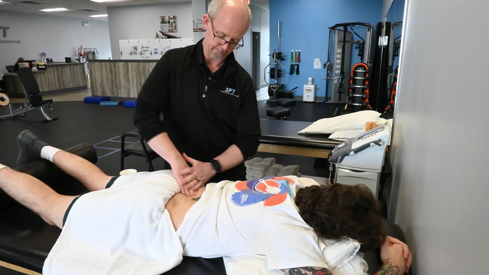 A 3PT Oak Lawn physical therapist performing hands-on manual therapy on a patient's lower back at the clinic.